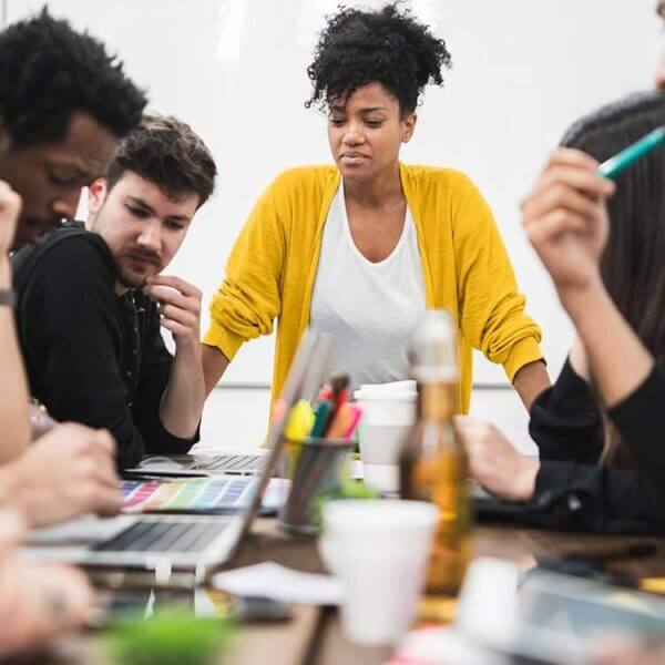 grupo de pessoas em uma mesa debatendo estratégias que serão abordadas em uma consultoria de redes sociais