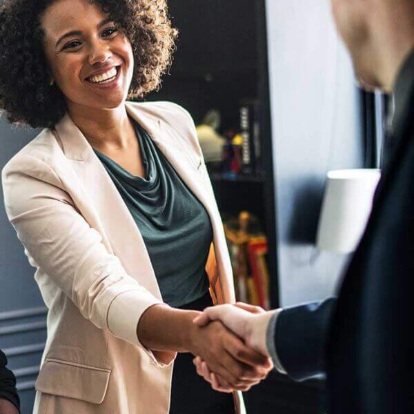 pessoa feliz dando um aperto de mãos após fechar um contrato de consultoria para redes sociais