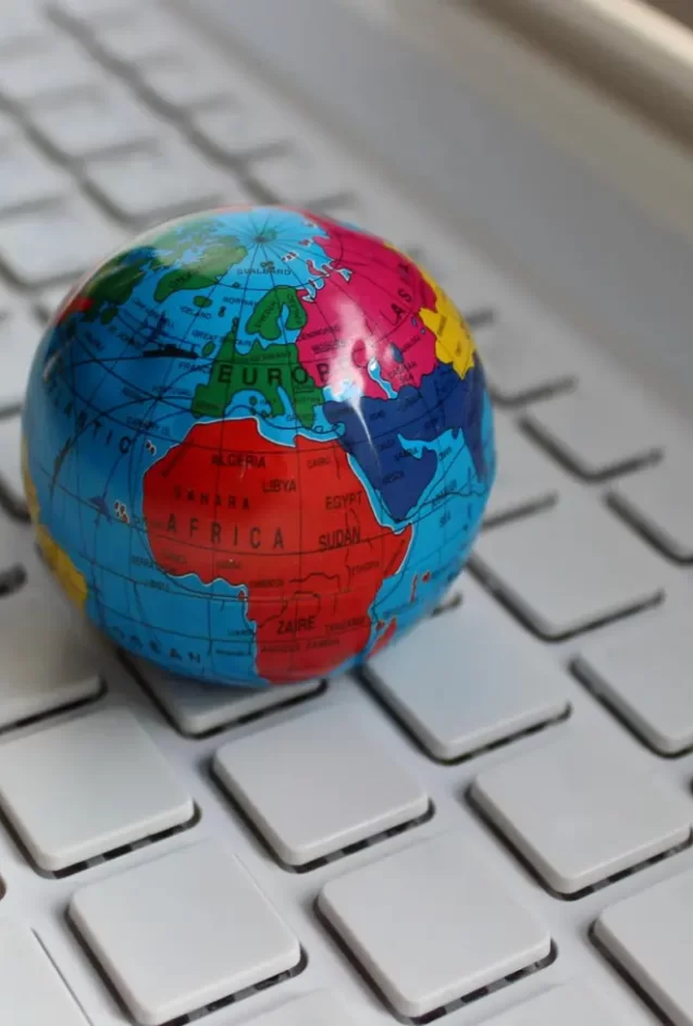 Vista em close-up de pequeno globo sobre um teclado de computador para representar o SEO internacional